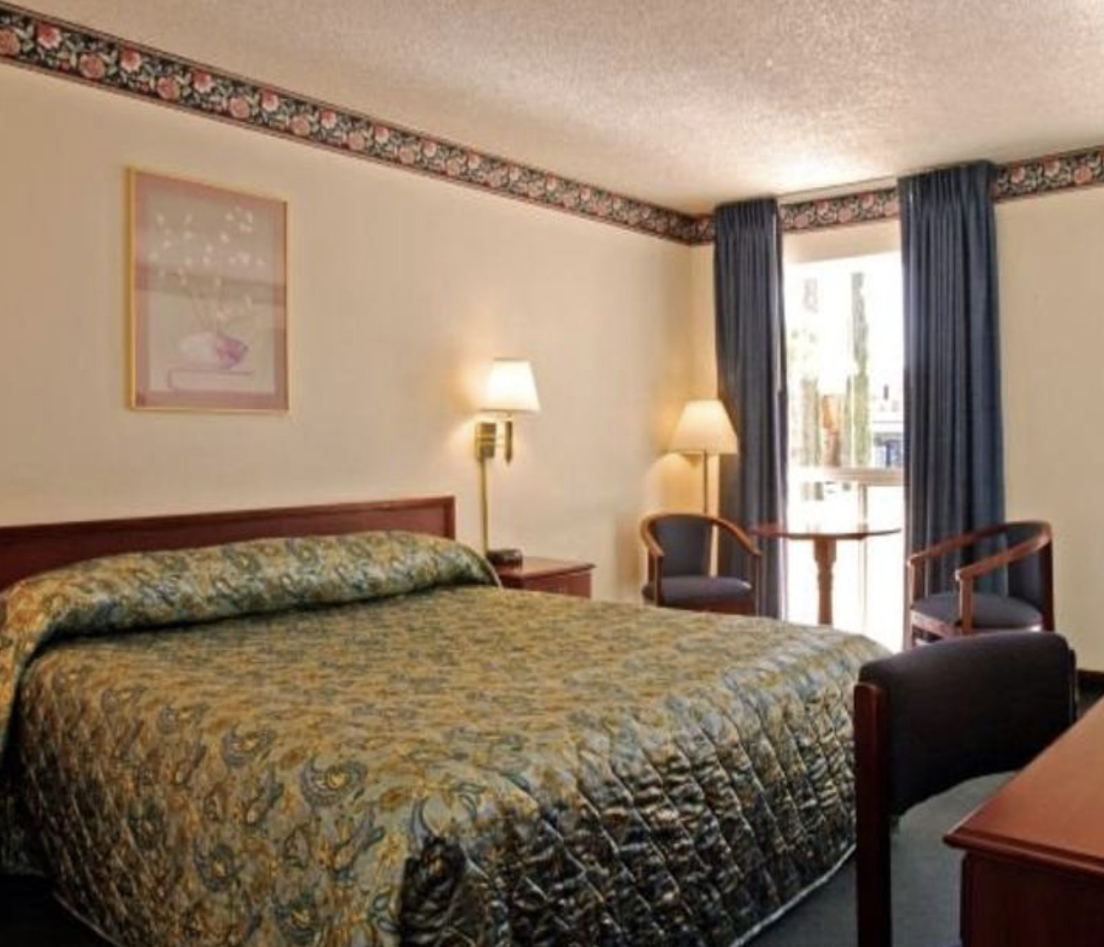 Queen bed room at El Dorado Inn Suites